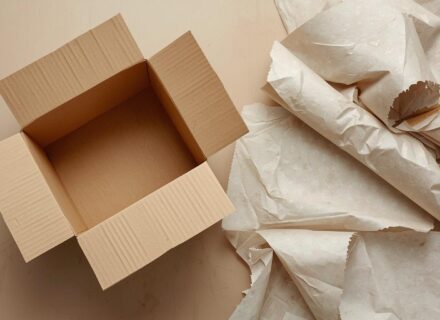 An empty box that has been opened with discarded paper around it